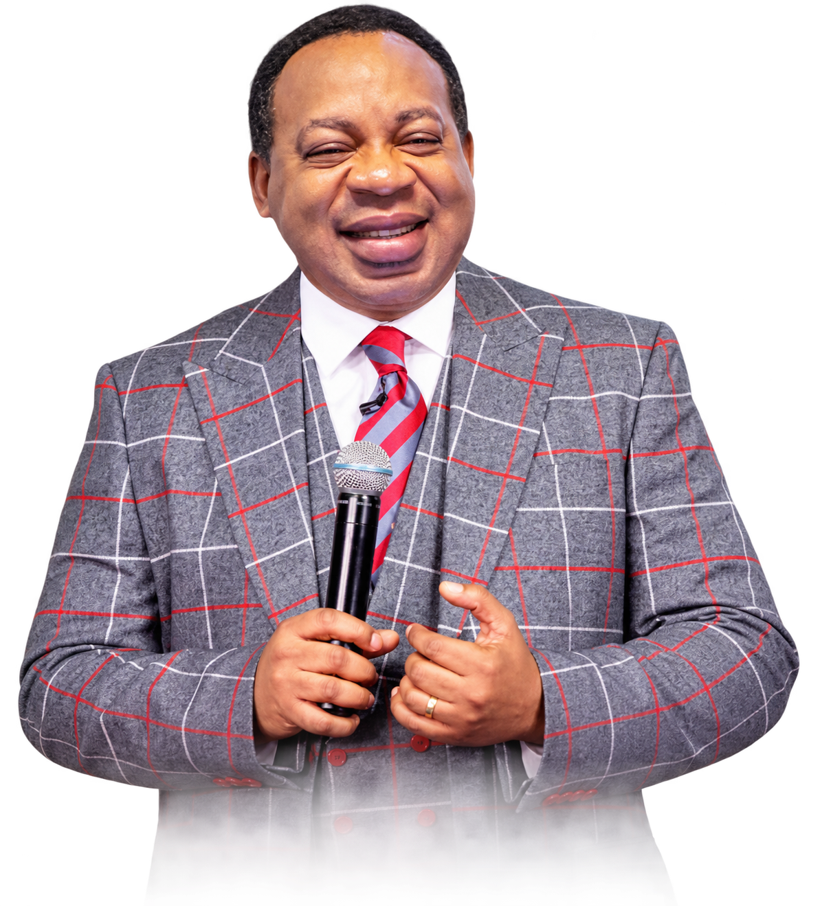 Rev. Ken Oyakhilome smiling warmly while holding a microphone